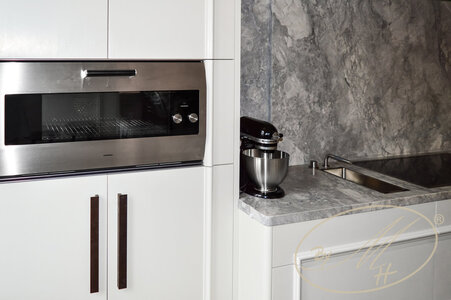 Material: MDF, solid wood, paint. Detail of the continuous profile of the kitchen unit.